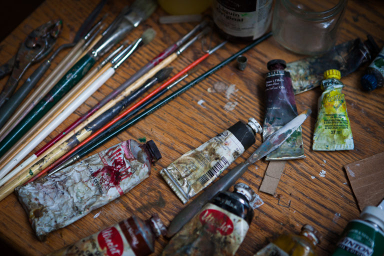 Lennart Anderson studio interior with dirty paint tubes and brushes on oak table