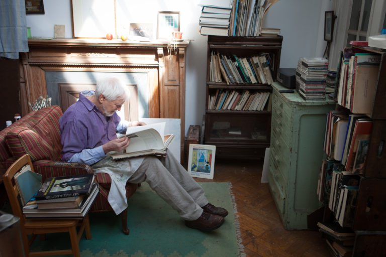 Lennart Anderson sitting in a chair in his studio with sunlight from above.