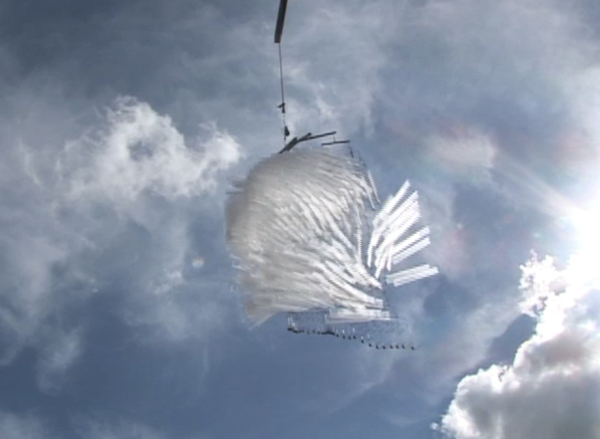 Short video of Tim Prentice's kinetic sculpture "Dances with Clouds", shot from below, a complex organic form made of white Lexan moving and waving like a feather in the wind with blustery sky as a backdrop.