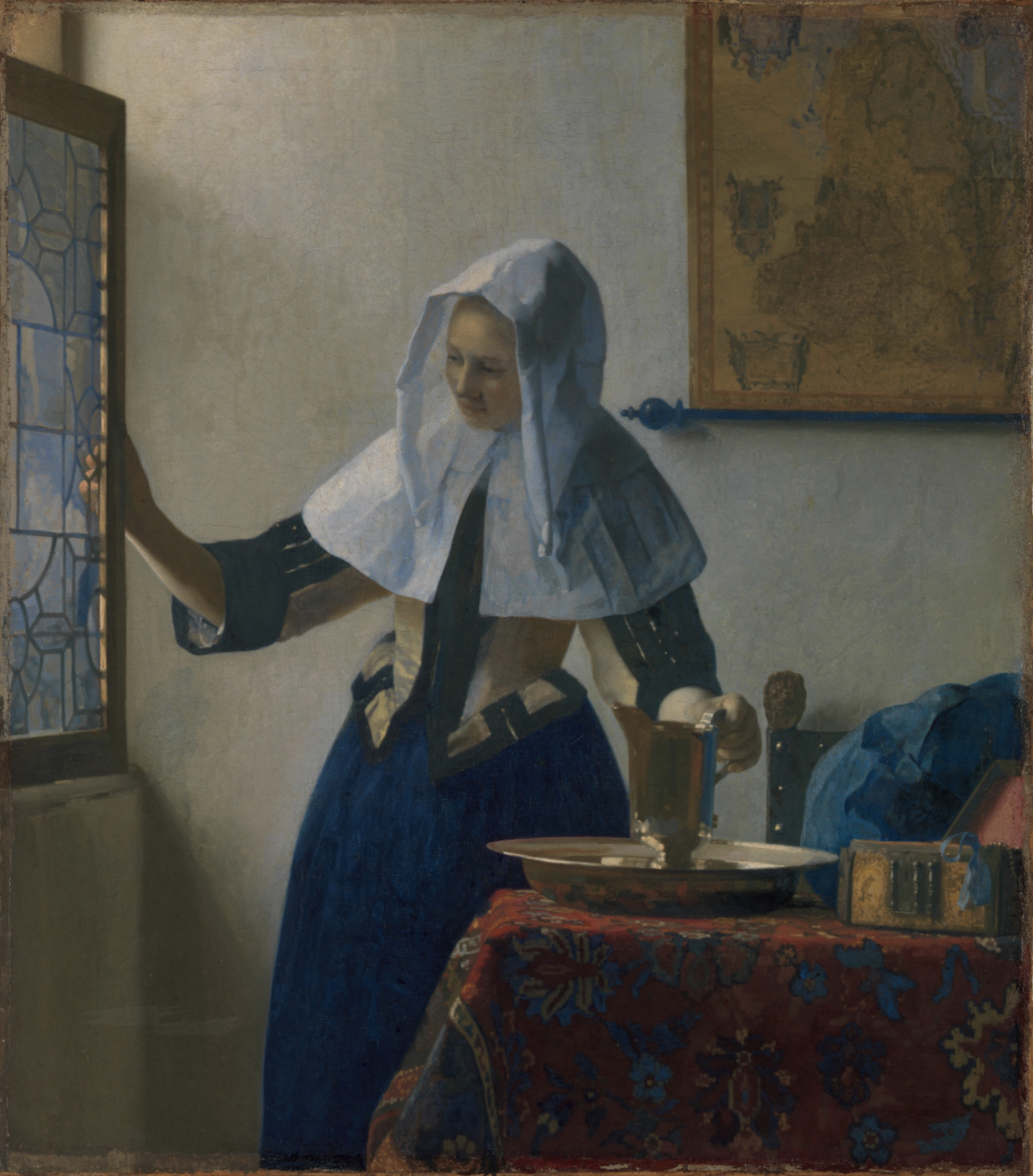 A full-color oil painting of a 17th-century domestic interior depicting a young woman standing in a room lost in thought. There is an open window to her left, and to her right a table, on which sits a plate and a water pitcher. The room is bathed in diffuse natural light. The woman, who wears a full-length blue dress and white headdress, rests one hand on the open window sash to her left, and one hand on the handle of the water pitcher to her right. The scene presents a poignant moment where time appears to have stopped.